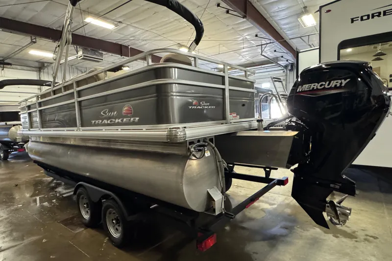 Slide: The Image of 2024 Sun Tracker Fishin' Barge 20 DLX pontoon boat with Mercury engine in a garage. - 6