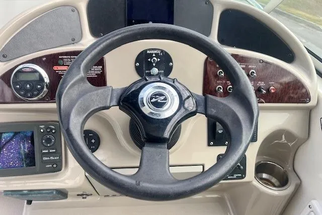 Slide: The Image of 2006 Sea Ray Sundancer 260 dashboard with steering wheel and control panel. - 11