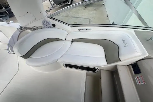 Slide: The Image of Interior seating of 2006 Sea Ray Sundancer 260 boat, featuring white and gray upholstery. - 13