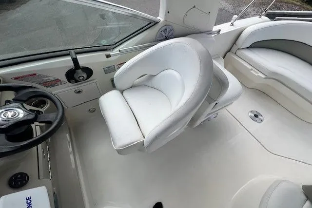 Slide: The Image of 2006 Sea Ray Sundancer 260 boat interior with white seating and steering wheel. - 14