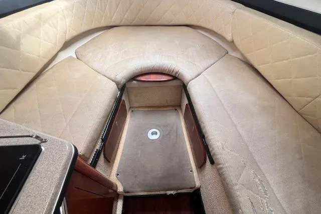 Slide: The Image of Interior cabin of 2006 Sea Ray Sundancer 260 with beige upholstery and compact layout. - 18