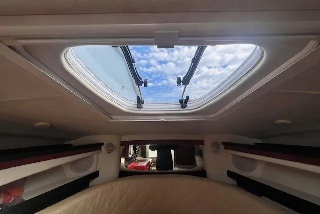 Slide: The Image of 2006 Sea Ray Sundancer 260 cabin interior with open skylight and blue sky view. - 19