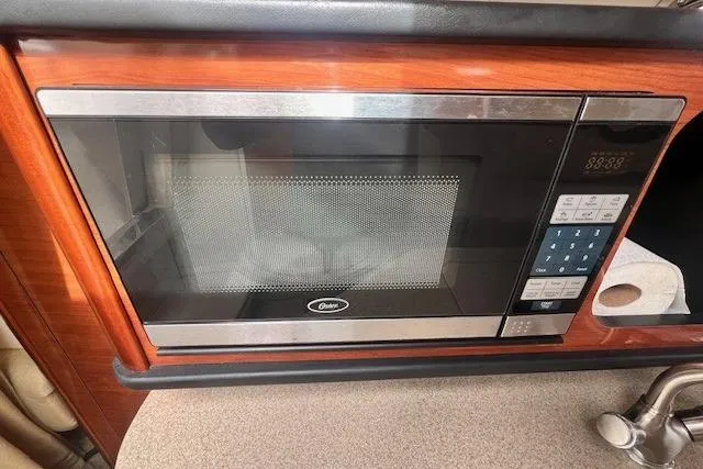 Slide: The Image of Microwave in 2006 Sea Ray Sundancer 260 boat kitchen, featuring wood paneling. - 20