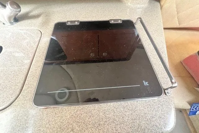 Slide: The Image of 2006 Sea Ray Sundancer 260 interior with a sleek black glass cooktop. - 21