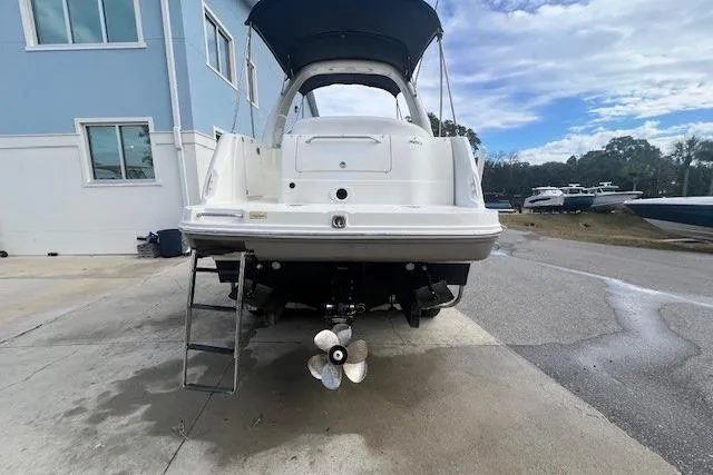 Slide: The Image of 2006 Sea Ray Sundancer 260 boat docked, rear view with propeller and ladder. - 3