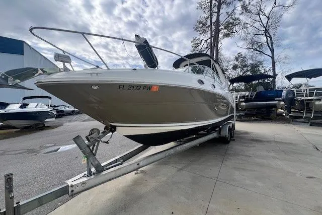 Slide: The Image of 2006 Sea Ray Sundancer 260 boat on trailer, parked outdoors under cloudy sky. - 5