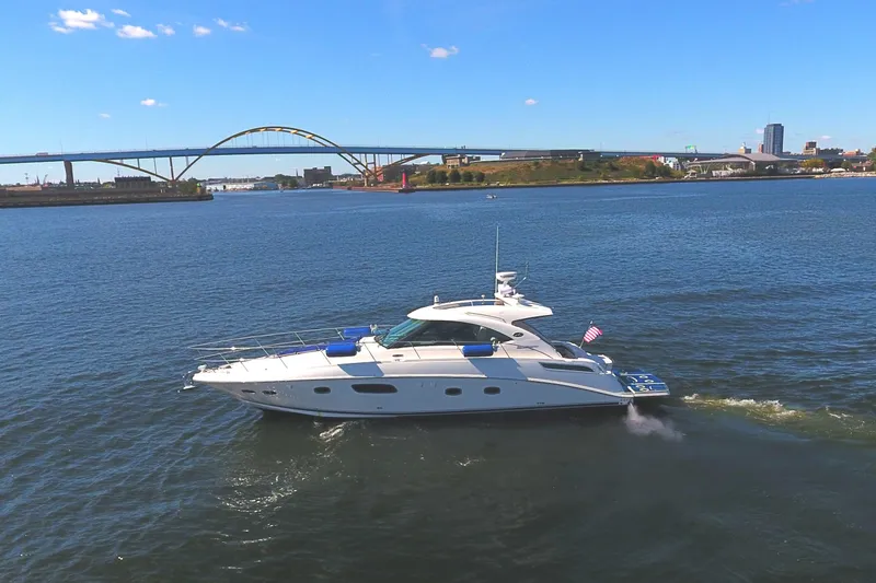 Slide: The Image of 2011 Sea Ray 470 Sundancer yacht cruising on a sunny day near a bridge. - 17