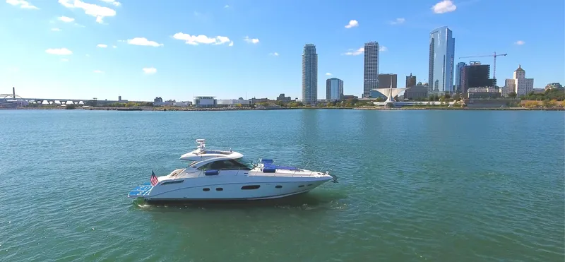 Slide: The Image of Sea Ray 470 Sundancer 2011 yacht on calm water with city skyline backdrop. - 2