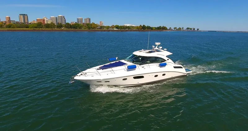 Slide: The Image of 2011 Sea Ray 470 Sundancer yacht cruising on a sunny day near city skyline. - 21