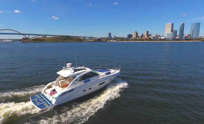 Slide: The Image of 2011 Sea Ray 470 Sundancer cruising on a river with city skyline in the background. - 23