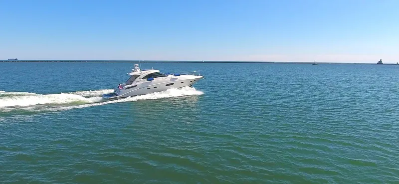 Slide: The Image of 2011 Sea Ray 470 Sundancer cruising on open water under clear blue skies. - 27