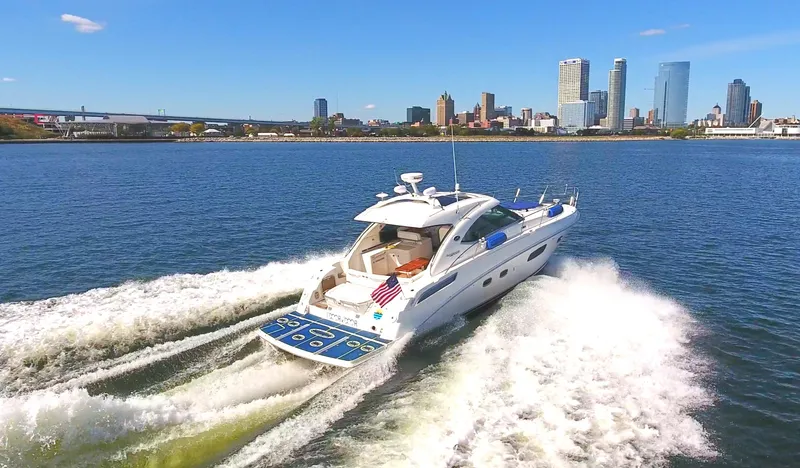 Slide: The Image of 2011 Sea Ray 470 Sundancer cruising on water with city skyline in background. - 29