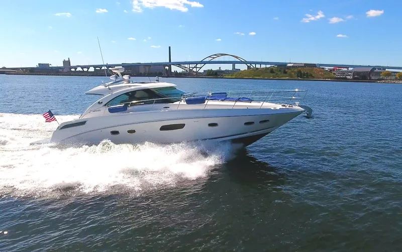Slide: The Image of 2011 Sea Ray 470 Sundancer cruising on a sunny day with a bridge in the background. - 33