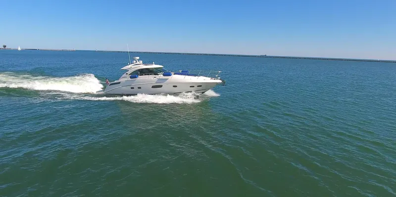 Slide: The Image of 2011 Sea Ray 470 Sundancer cruising on open water under clear blue skies. - 34