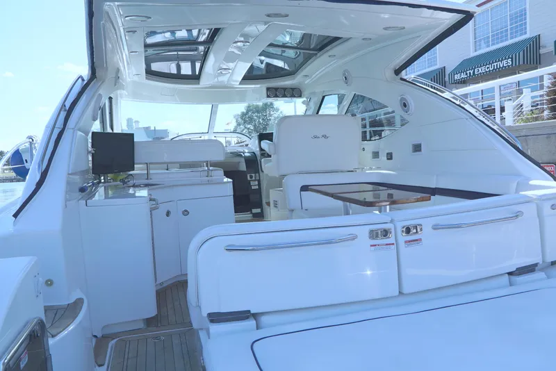 Slide: The Image of 2011 Sea Ray 470 Sundancer yacht interior with sleek white seating and modern amenities. - 38