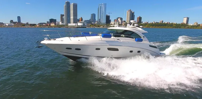 Slide: The Image of 2011 Sea Ray 470 Sundancer cruising on water with city skyline in background. - 9