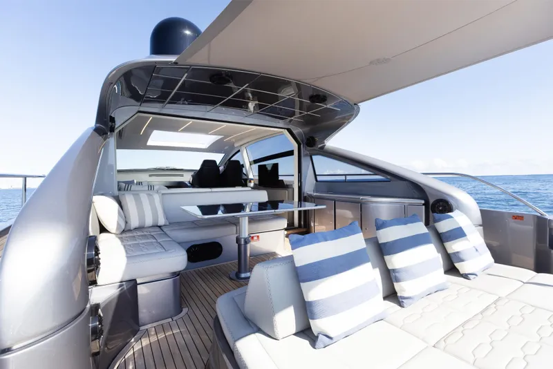 Slide: The Image of Luxurious 2016 Pershing 62 yacht interior with striped cushions, sleek design, and ocean view. - 15