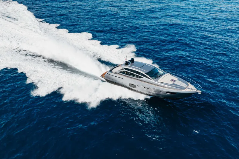 Slide: The Image of 2016 Pershing 62 yacht cruising on open blue sea, creating a dynamic wake. - 4