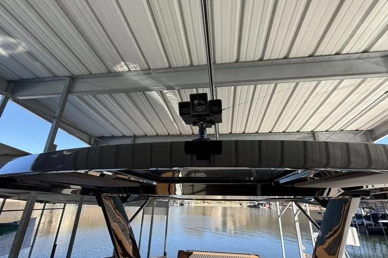 Slide: The Image of 2025 Cobalt R35 boat under a metal canopy, docked by the water. - 12