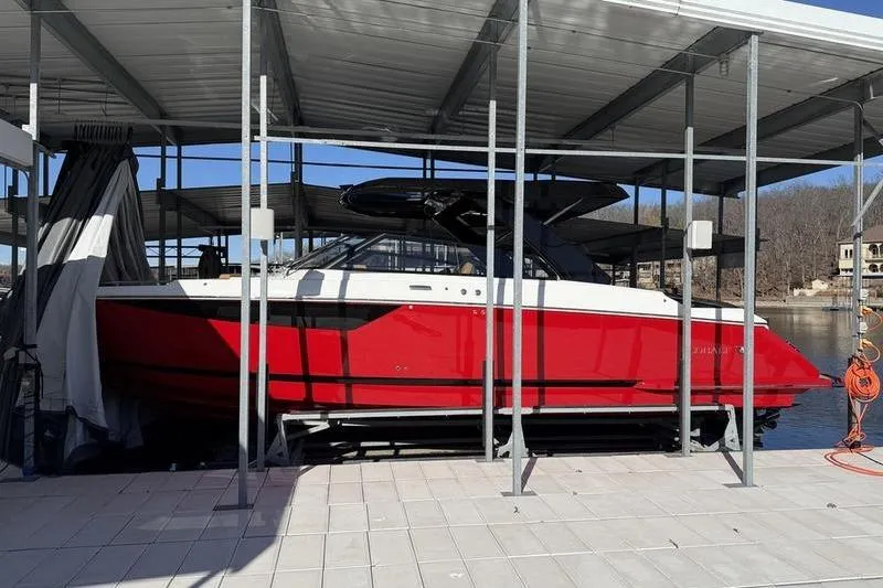 Slide: The Image of Red 2025 Cobalt R35 boat docked under a covered marina. - 13