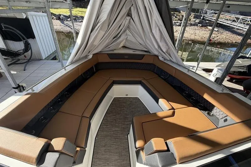 Slide: The Image of 2025 Cobalt R35 boat interior with tan seating and covered canopy. - 14