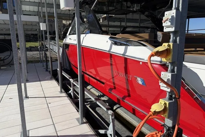 Slide: The Image of Red 2025 Cobalt R35 boat docked with visible power connections. - 2