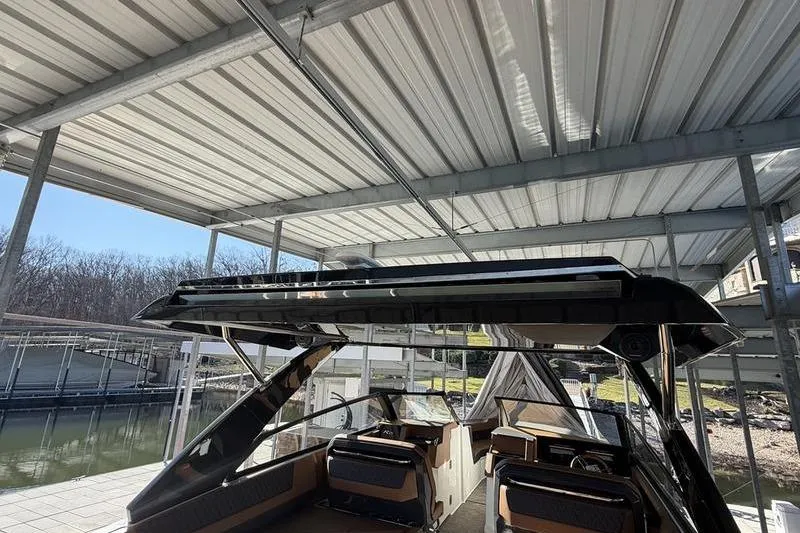 Slide: The Image of 2025 Cobalt R35 boat under a metal canopy at a marina. - 27