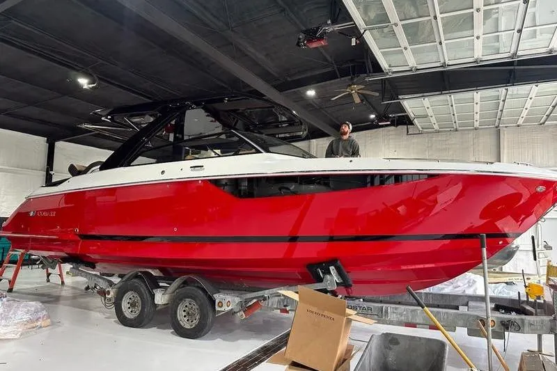 Slide: The Image of 2025 Cobalt R35 boat in a garage, vibrant red hull on a trailer. - 4
