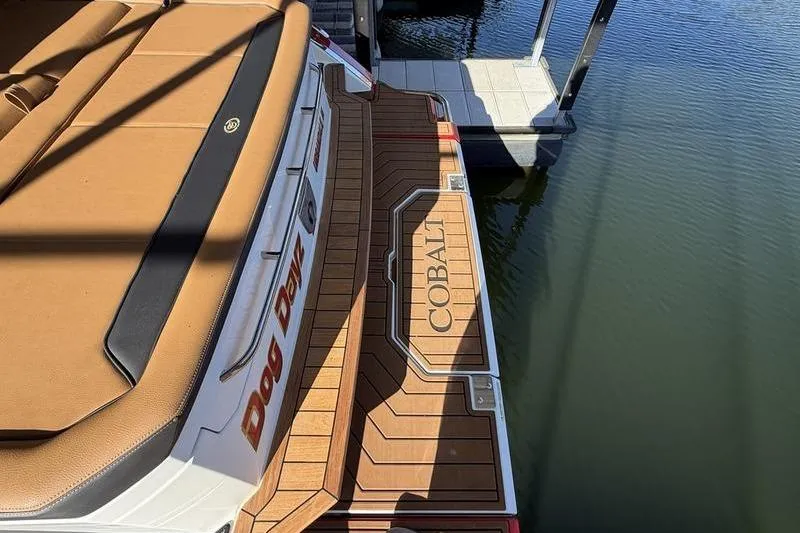 Slide: The Image of 2025 Cobalt R35 boat with tan seating and wooden deck by the water. - 5