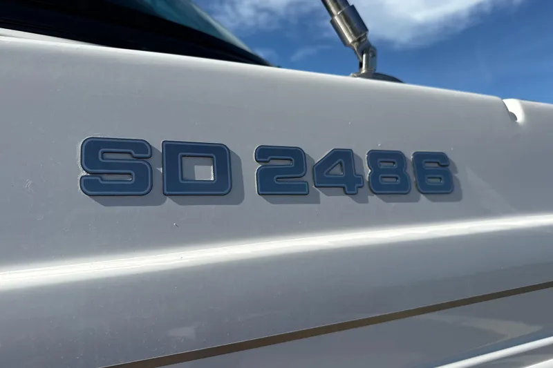 Slide: The Image of 2018 Hurricane SunDeck 2486 OB boat model emblem against blue sky. - 13