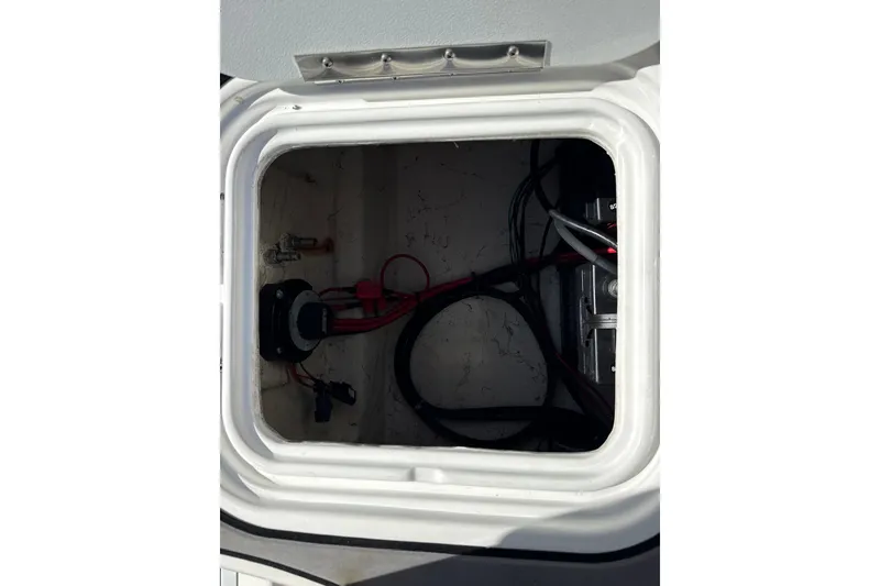 Slide: The Image of 2018 Hurricane SunDeck 2486 OB storage compartment with wiring and components. - 15