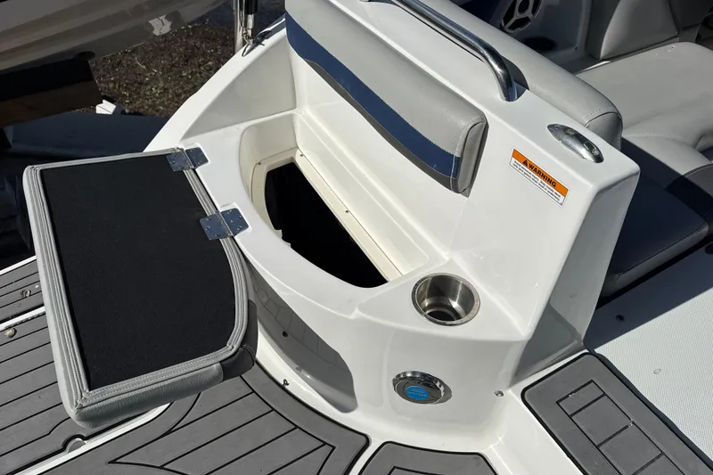 Slide: The Image of 2018 Hurricane SunDeck 2486 OB boat storage compartment with open lid and cup holder. - 17