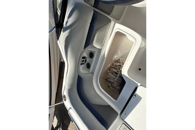 Slide: The Image of 2018 Hurricane SunDeck 2486 OB boat interior with storage compartment and coiled rope. - 31
