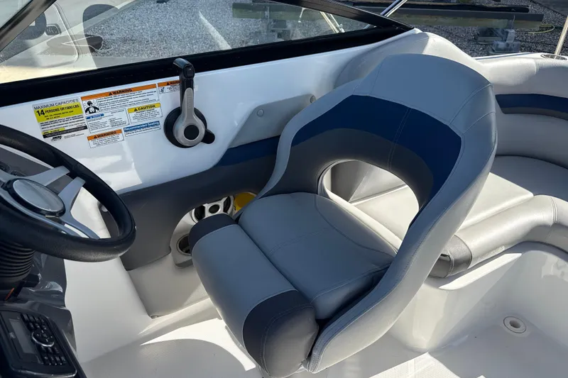 Slide: The Image of 2018 Hurricane SunDeck 2486 OB boat interior with steering wheel and cushioned seating. - 33