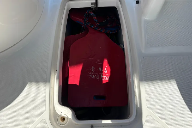 Slide: The Image of Storage compartment on 2018 Hurricane SunDeck 2486 OB boat with red life jacket. - 39