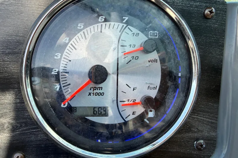 Slide: The Image of Close-up of 2018 Hurricane SunDeck 2486 OB dashboard gauge showing RPM, voltage, and fuel levels. - 42