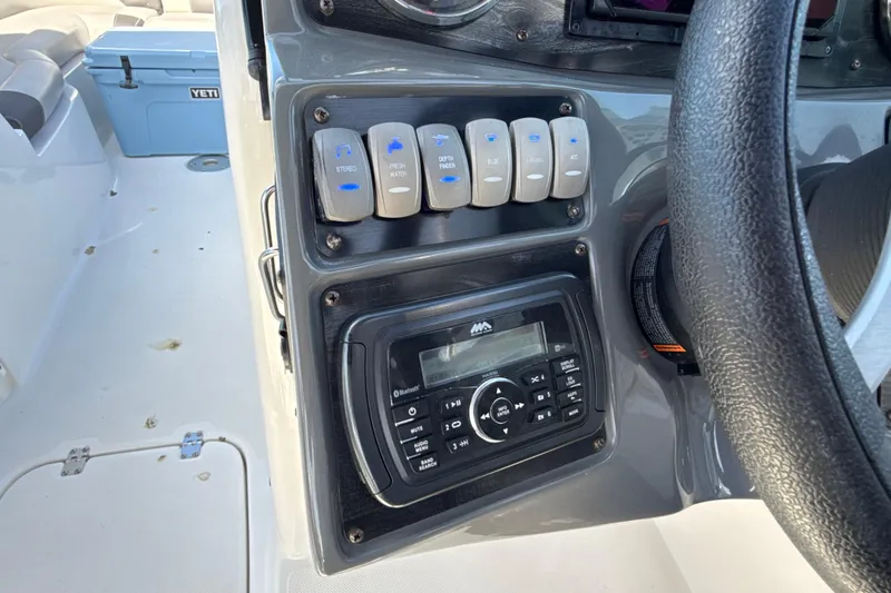 Slide: The Image of Control panel of 2018 Hurricane SunDeck 2486 OB boat with switches and stereo system. - 45