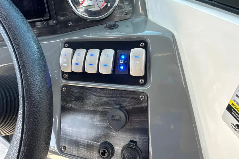 Slide: The Image of Control panel of 2018 Hurricane SunDeck 2486 OB boat with switches and audio input. - 46