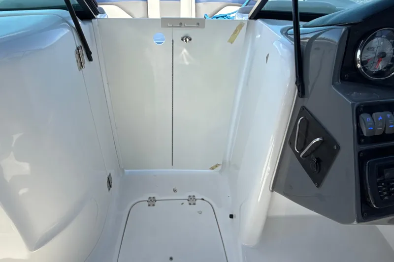 Slide: The Image of 2018 Hurricane SunDeck 2486 OB interior helm with control panel and storage area. - 48