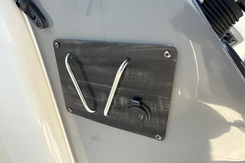 Slide: The Image of 2018 Hurricane SunDeck 2486 OB boat detail with metal handle and power outlet. - 49