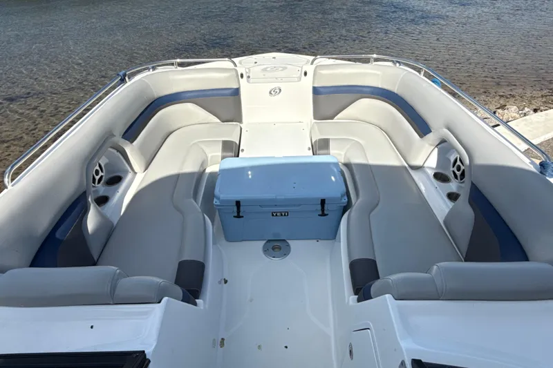 Slide: The Image of 2018 Hurricane SunDeck 2486 OB boat interior with seating and cooler on calm water. - 50