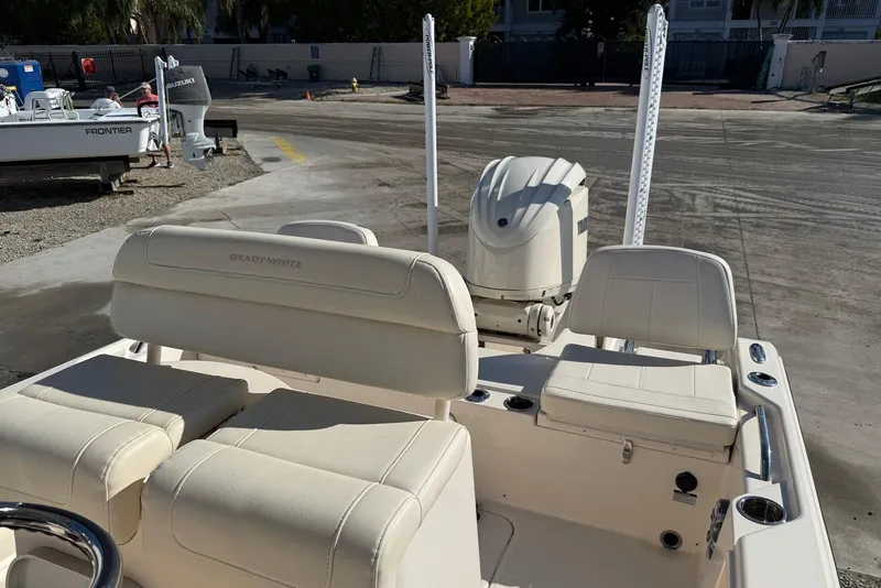 Slide: The Image of 2024 Grady-White 231 Coastal Explorer boat interior with seating and engine view. - 10
