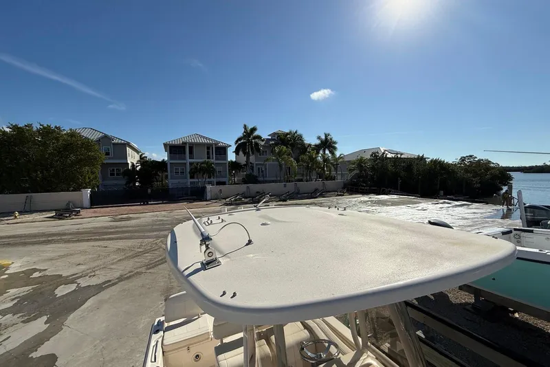 Slide: The Image of 2024 Grady-White 231 Coastal Explorer boat docked near waterfront homes under clear sky. - 18