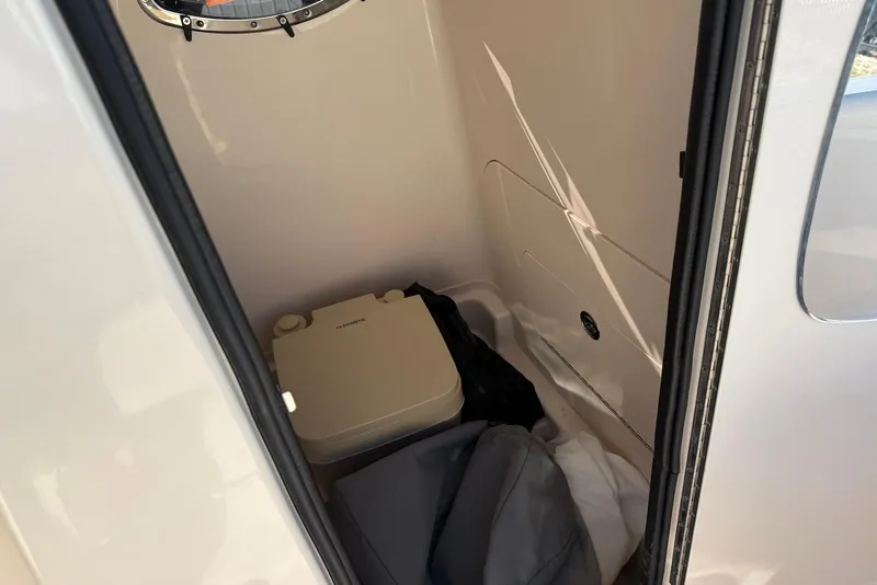Slide: The Image of 2024 Grady-White 231 Coastal Explorer interior with portable toilet and storage area. - 21