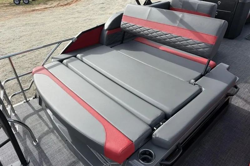 Slide: The Image of 2026 Godfrey Monaco 235 SFL boat interior with gray and red seating, featuring a speaker. - 27