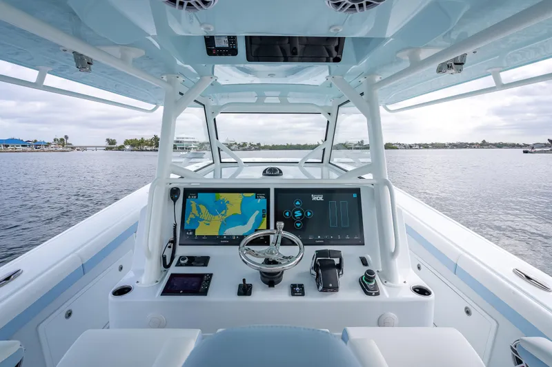 Slide: The Image of 2026 Yellowfin 42 Offshore boat cockpit with advanced navigation system on calm waters. - 13