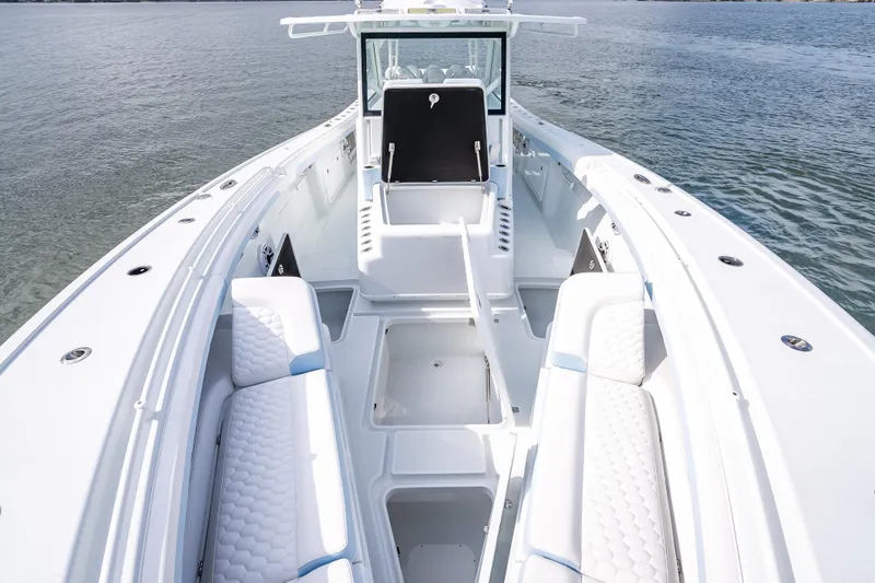 Slide: The Image of 2026 Yellowfin 42 Offshore boat interior with white seating and open storage compartments. - 19