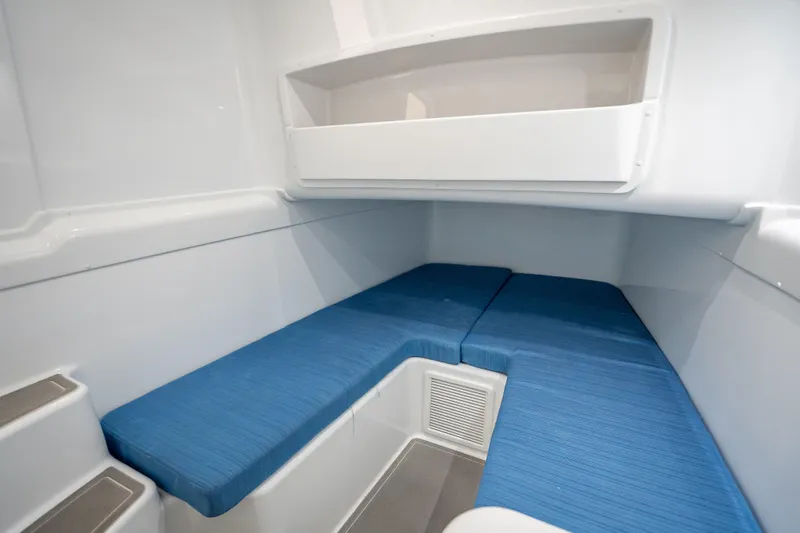 Slide: The Image of 2026 Yellowfin 42 Offshore cabin interior with blue seating and white storage shelf. - 34