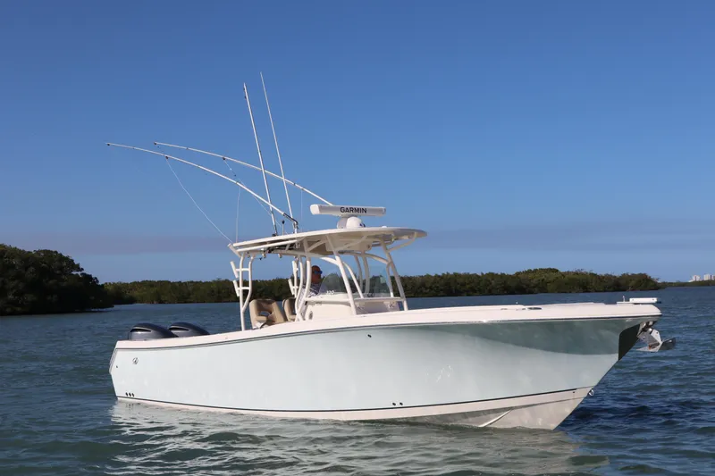 The Image of 2017 Sailfish 320 CC boat on calm water with clear blue sky. - 0