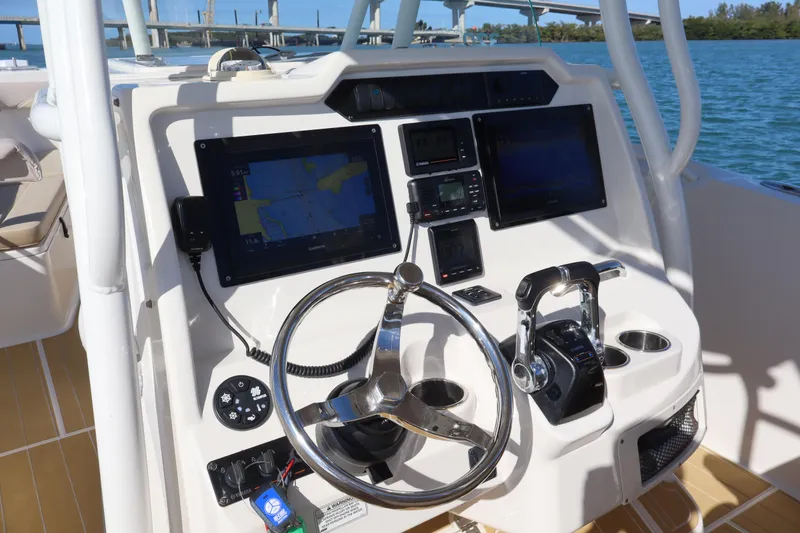 Slide: The Image of 2017 Sailfish 320 CC boat dashboard with navigation screens and steering wheel. - 16